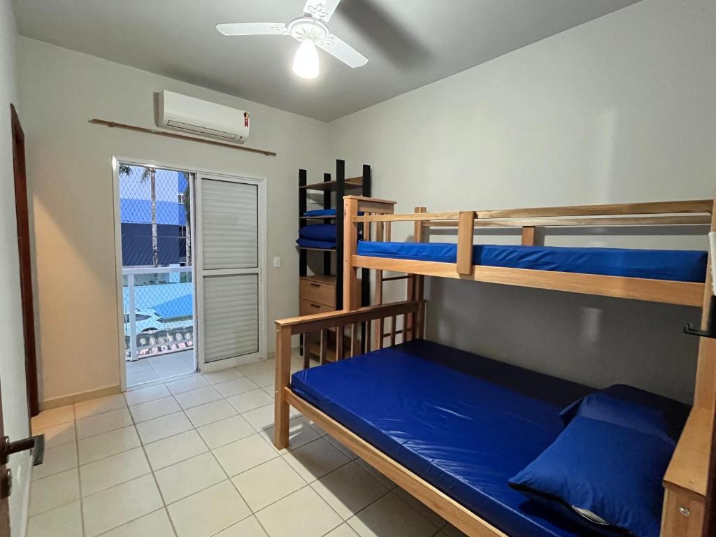 1 Schlafzimmer mit 2 Etagenbetten und einem Balkon in der Unterkunft Casa Pé na Areia com Piscina Climatizada in Bertioga