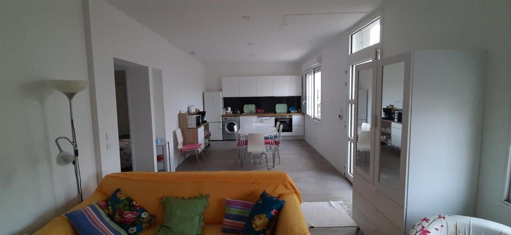 uma sala de estar com um sofá e uma cozinha em Maison ville agréable em Riorges