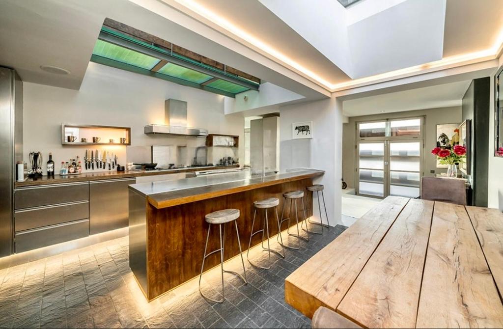 eine Küche mit einer Holztheke und einem Holztisch in der Unterkunft Unique,architecturally acclaimed,Notting Hill home in London