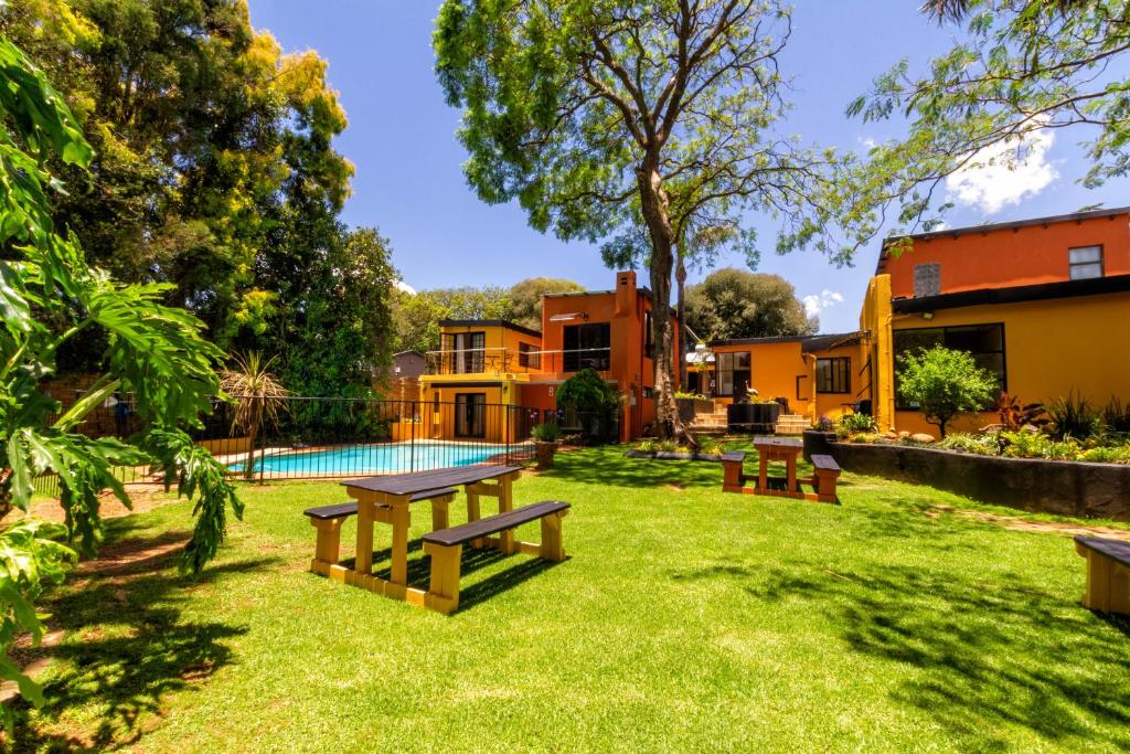 un patio con bancos y una piscina en Linden Guest House, en Johannesburgo