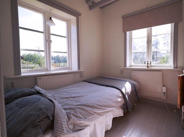 1 dormitorio con 1 cama y 2 ventanas en Luxury cosy cottage by the sea en Karlstad