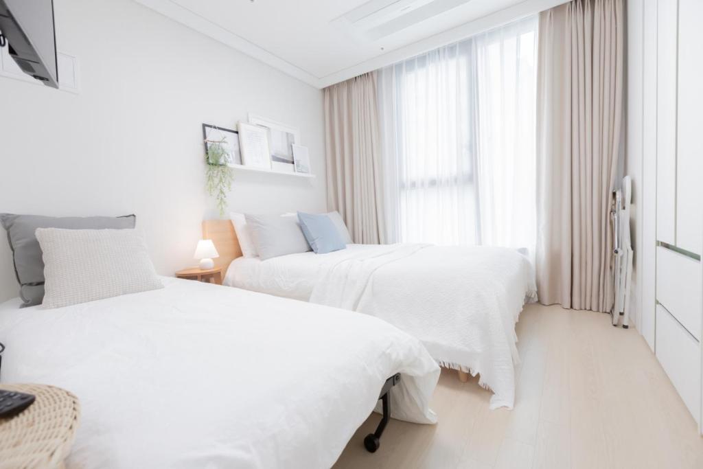 מיטה או מיטות בחדר ב-Apartment THE SHARE Myeongdong