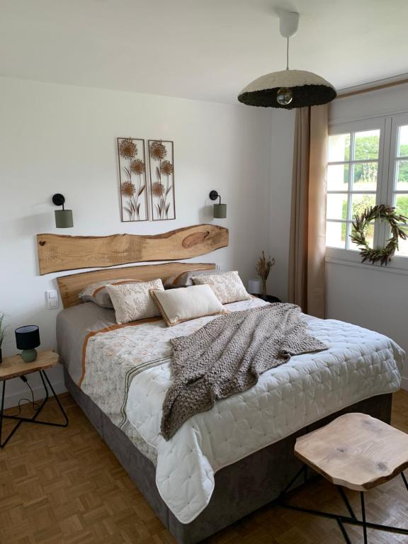 Schlafzimmer mit einem großen Bett mit einem Kopfteil aus Holz in der Unterkunft Le Ch’ti Breizh home in Cléguer