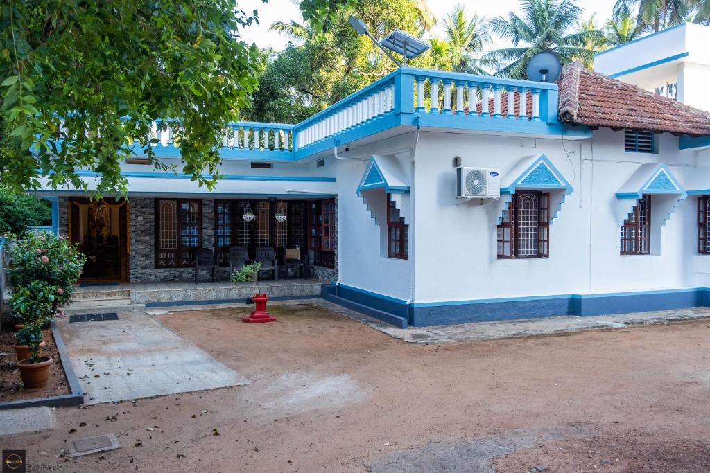 a blue and white house with a red fire hydrant at Reunion Pride Villa in Udupi