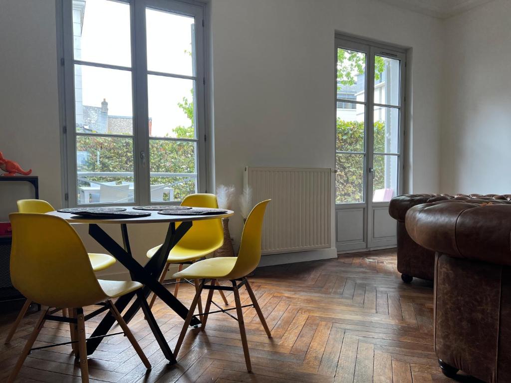 une salle à manger avec une table et des chaises jaunes dans l'établissement * Johnnie Walker * Hypercentre parking *, à Blois