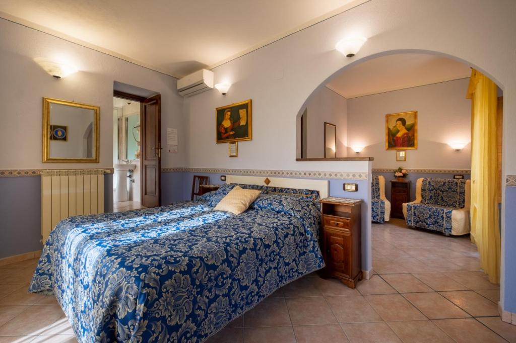 a bedroom with a bed with a blue comforter at B&B Locanda Il Tufo Rosa in Pitigliano