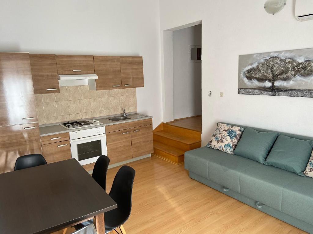 a kitchen and a living room with a couch and a table at Apartman Polegubic in Biograd na Moru
