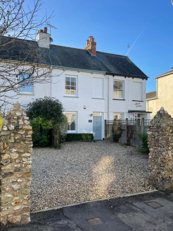 a large white house with a gravel driveway at Wren House in Sidmouth