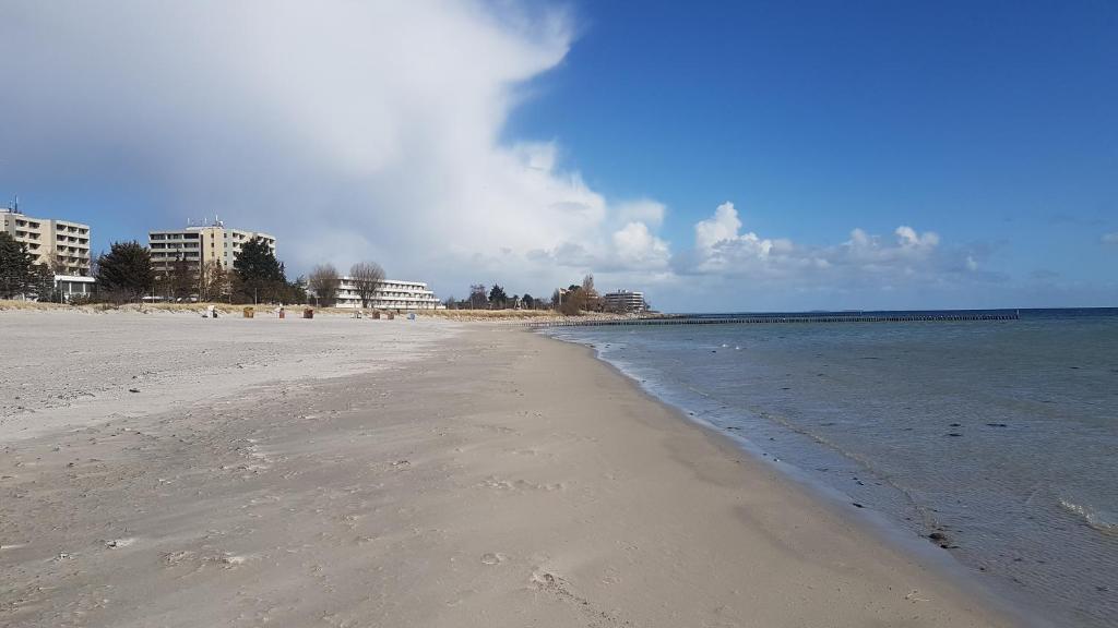 una playa con edificios en la distancia y el océano en Vier Jahreszeiten 3 37, en Großenbrode