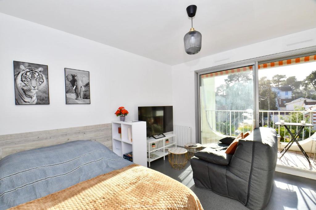 1 dormitorio con 1 cama, TV y ventana en A La Plage et Au Soleil de St Palais sur Mer en Saint-Palais-sur-Mer