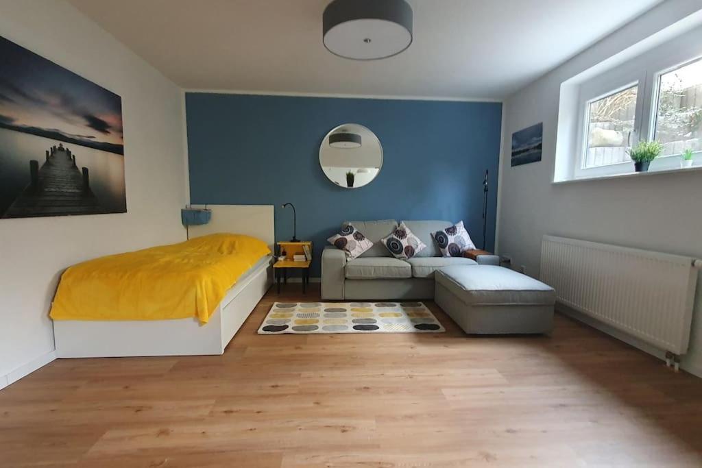 um quarto com uma cama e um sofá em Apartment_BaLi em Linkenheim-Hochstetten