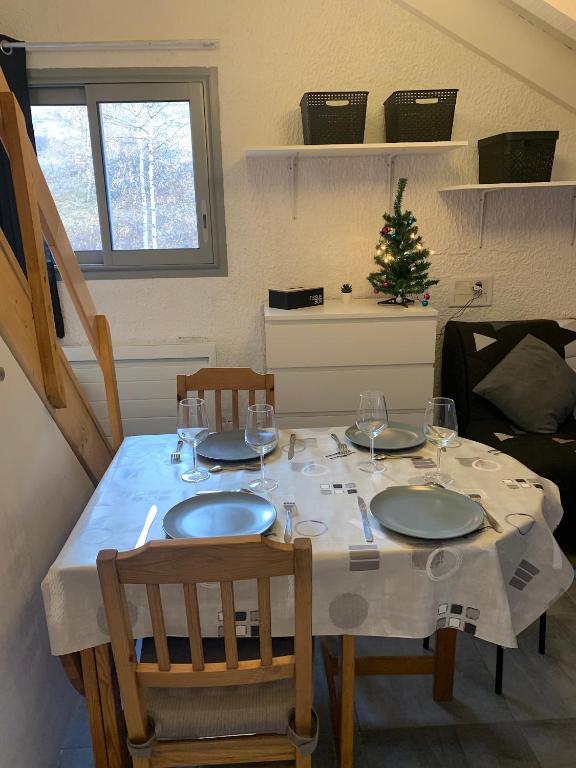 - une table avec deux chaises et une table avec des verres à vin dans l'établissement Les 2 Alpes studio centre station, à Les Deux Alpes