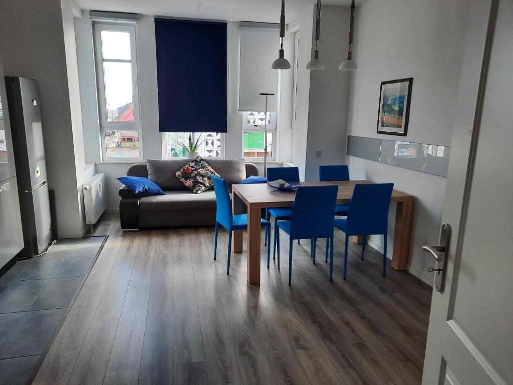 a living room with a table and chairs and a couch at Gästewohnung Alt Salbke mit Küche in Magdeburg