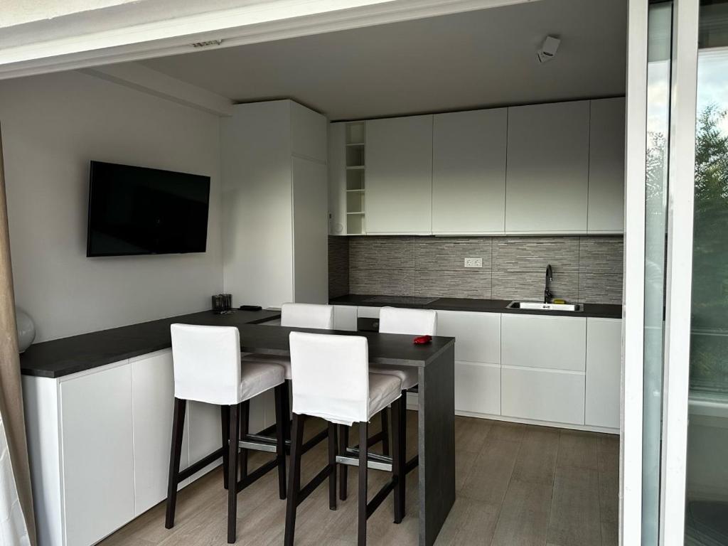 une cuisine avec une table noire et des chaises blanches dans l'établissement Apartment Torremolinos, à Torremolinos
