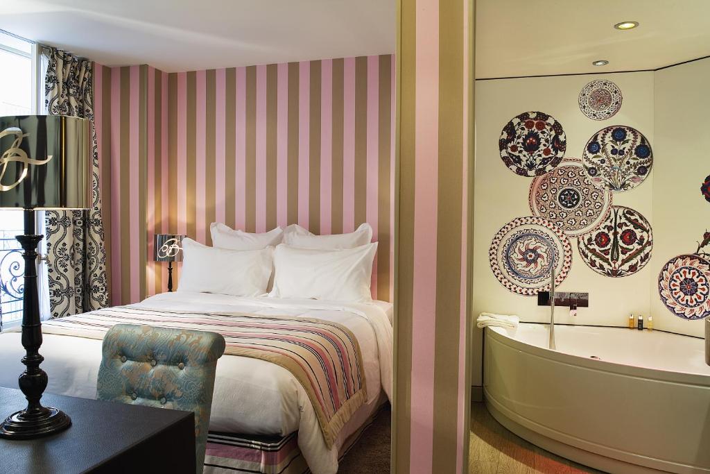 a hotel room with a bed and a bathtub at Hôtel Le Bellechasse Saint-Germain in Paris