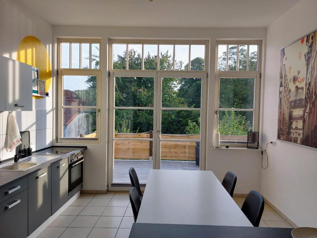 a kitchen with a table and chairs and windows at Stadthaus mit Dachterrasse in Varel