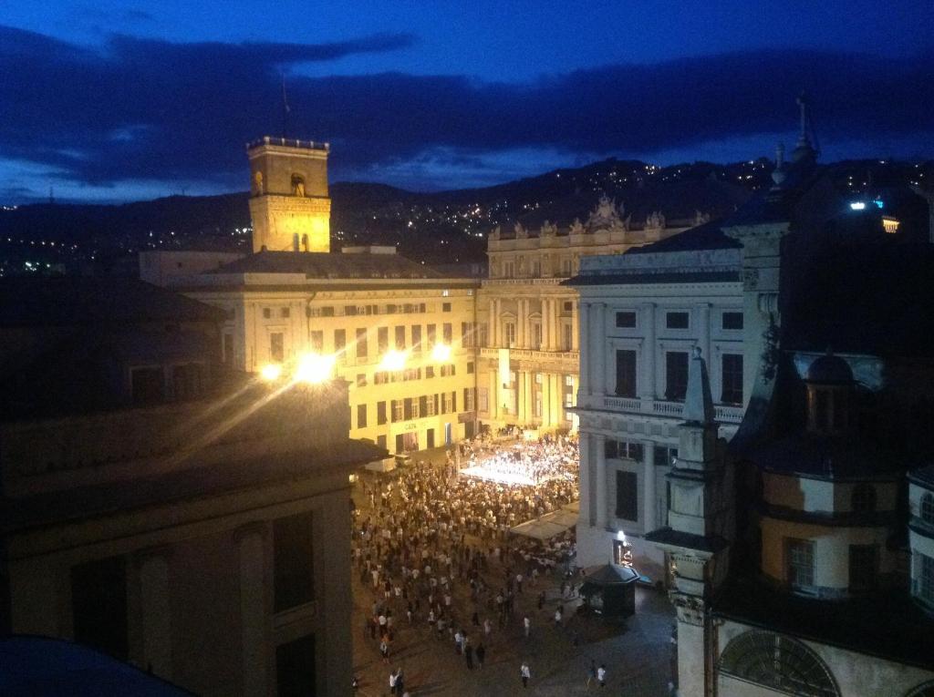 una multitud de personas frente a un edificio por la noche en Torre Ducale Dimora Storica, en Génova