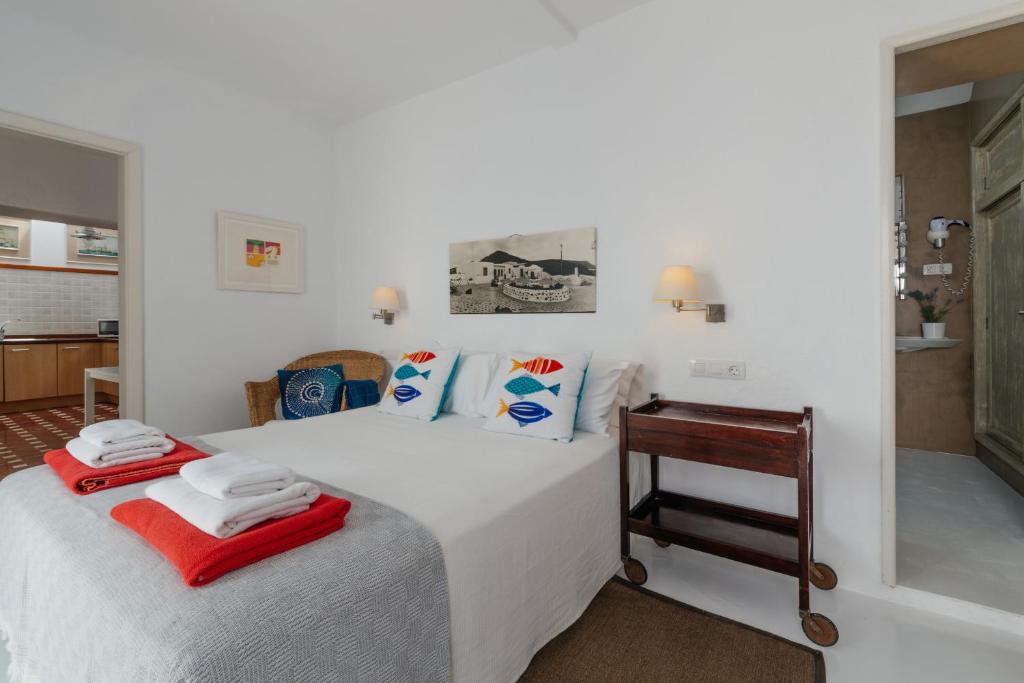 a bedroom with a white bed and a table at Casa Rural Caleton del Golfo in El Golfo