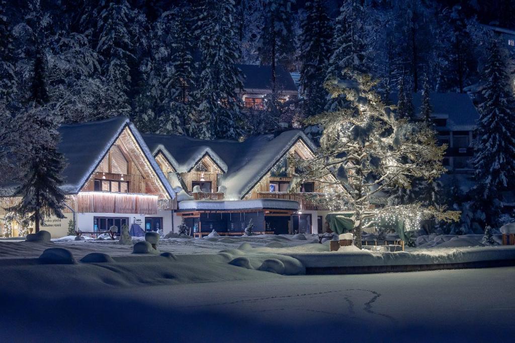 a large house with a christmas tree in front of it at Jasna Chalet Resort in Kranjska Gora
