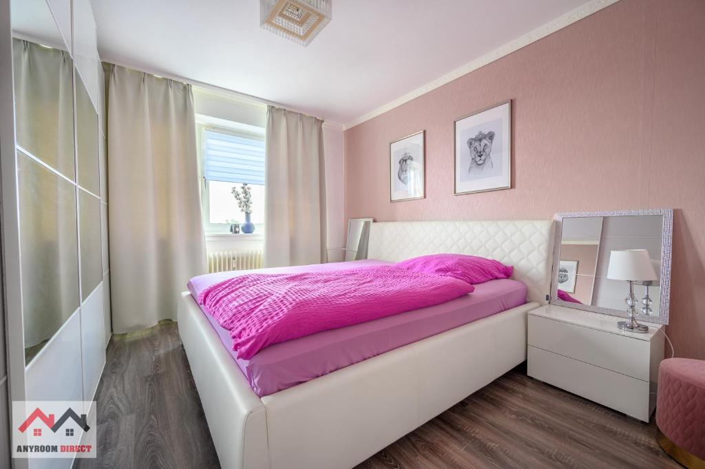 ハノーファーにあるAnyroomdirect Private Apartments Near Hannover Exhibition ROOM AGENCYのピンクのベッドルーム(ベッド1台、鏡付)