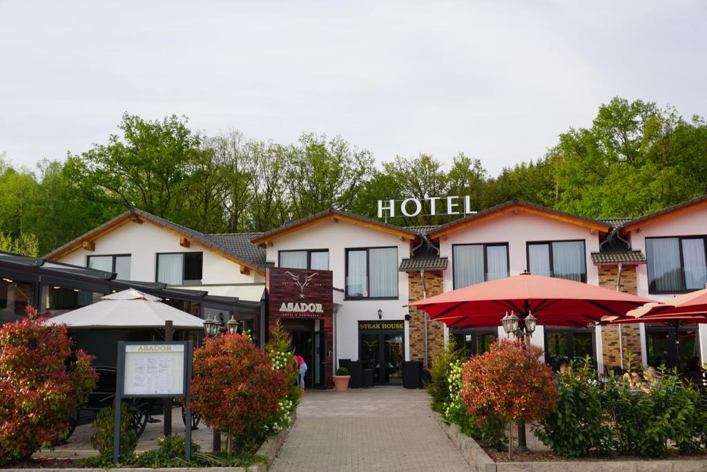 un hotel con sombrillas rojas delante en ASADOR, en Netphen