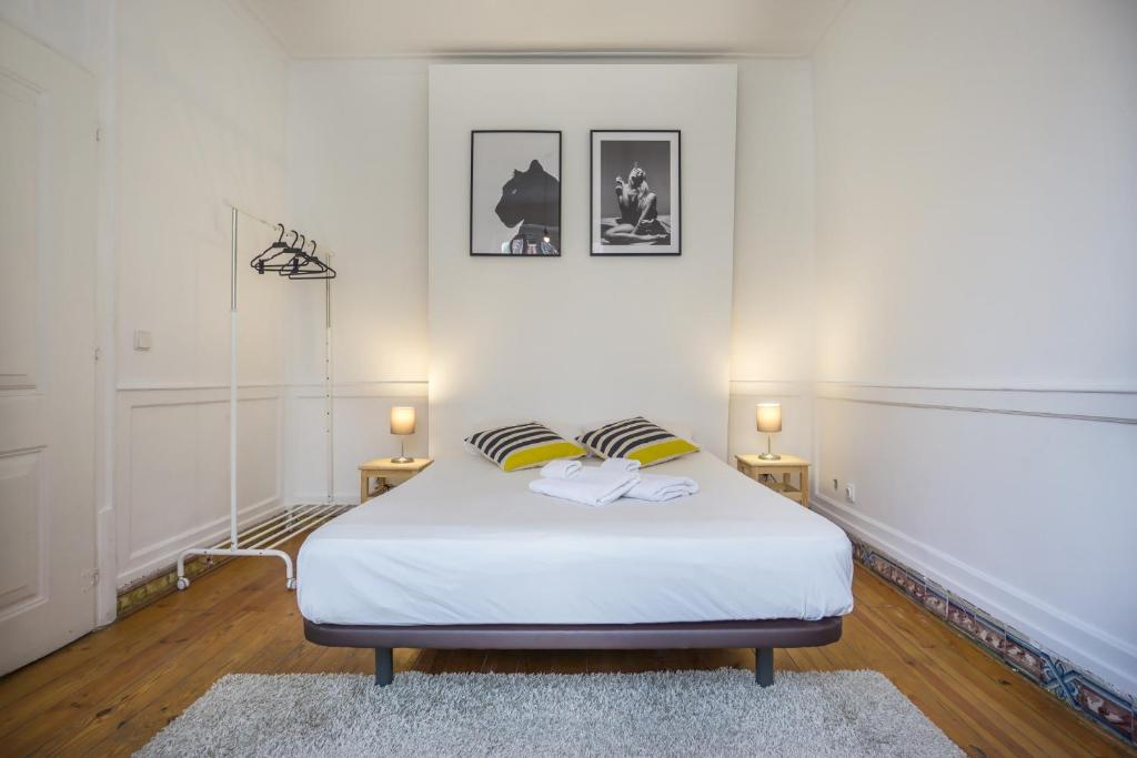 1 dormitorio con 1 cama blanca y 2 lámparas en Original Lisbon Guesthouse, en Lisboa