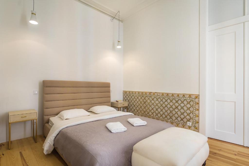a bedroom with a bed with two towels on it at Santa Justa Prime Guesthouse in Lisbon