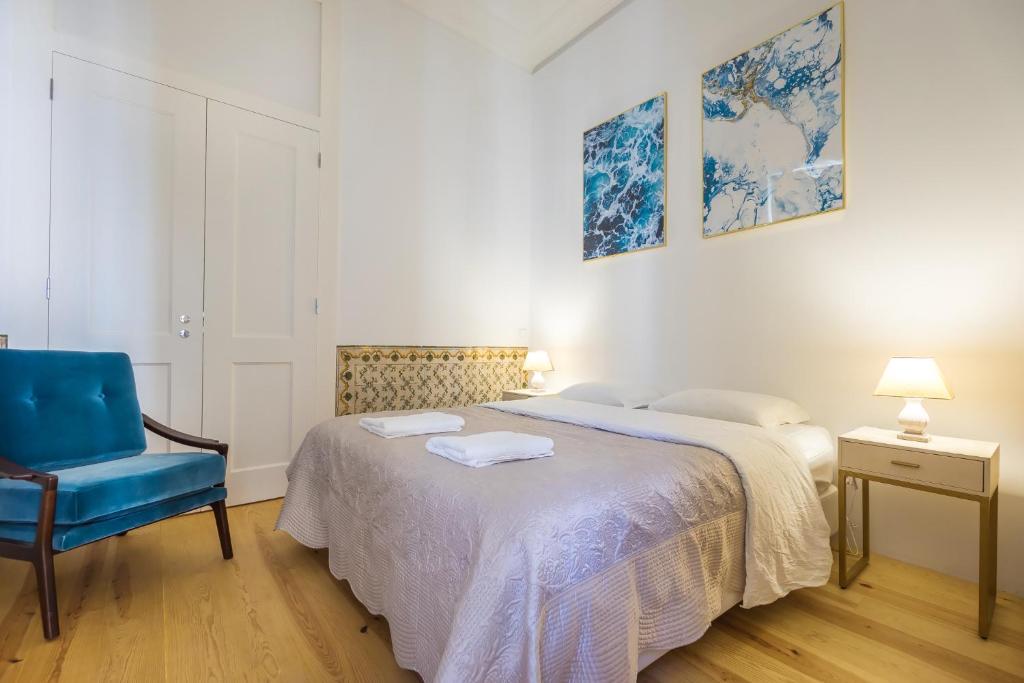 une chambre avec un lit et une chaise bleue dans l'établissement Santa Justa Prime Guesthouse, à Lisbonne