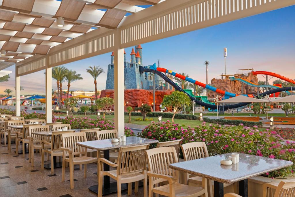 un patio con tavoli, sedie e montagne russe di Pickalbatros Aqua Blu Sharm El Sheikh a Sharm El Sheikh