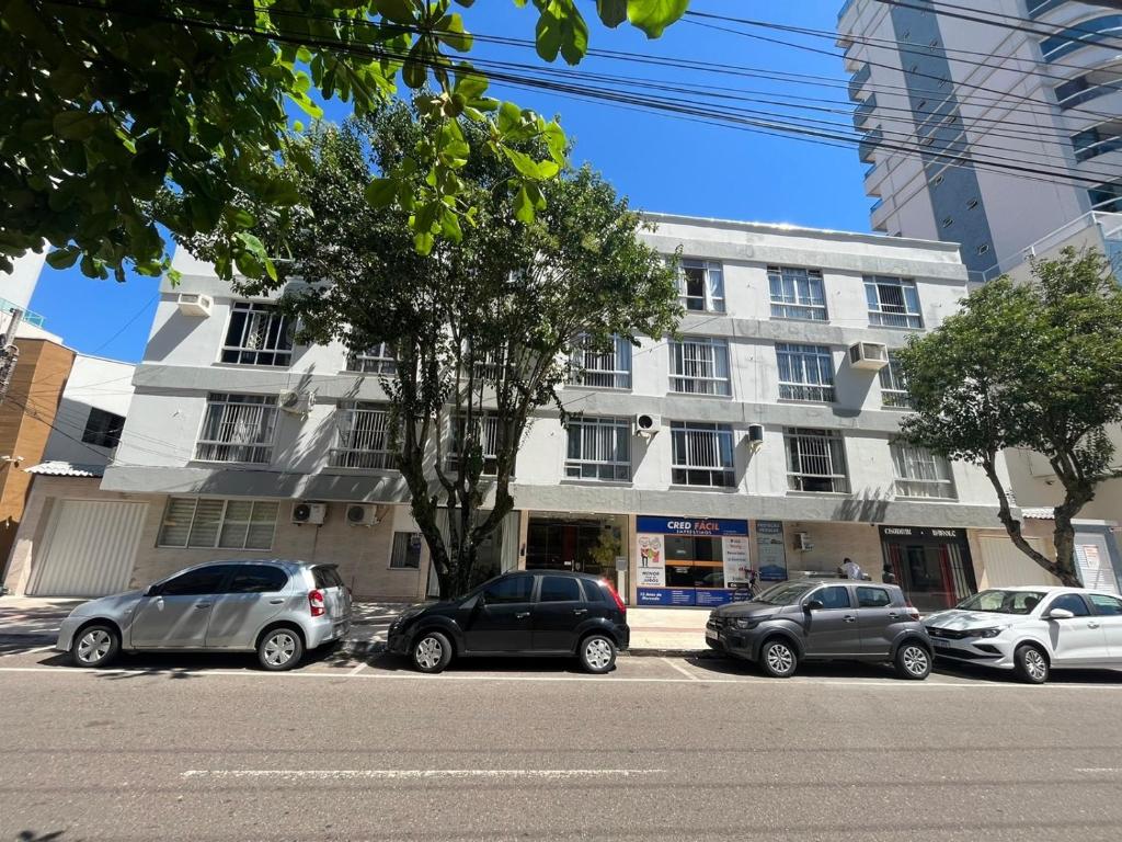 un grupo de coches estacionados frente a un edificio en Residencial nautilus 303, en Balneário Camboriú