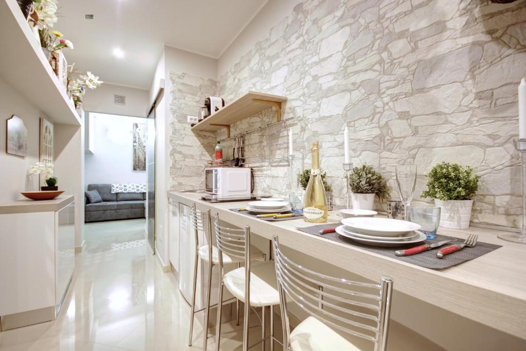 een keuken met een aanrecht met stoelen en een stenen muur bij MilanRentals - Charlie Apartment in Milaan