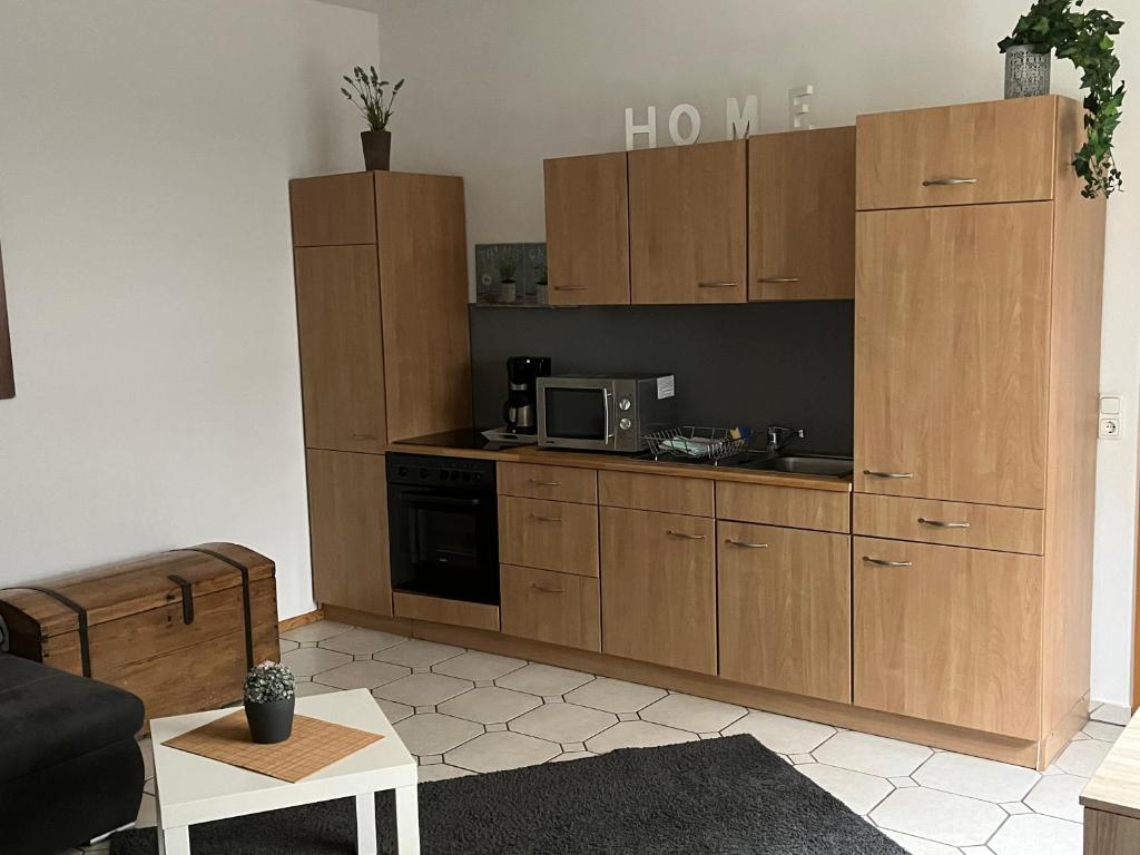 a kitchen with wooden cabinets and a microwave at Ferienwohnung Staufenberg in Staufenberg