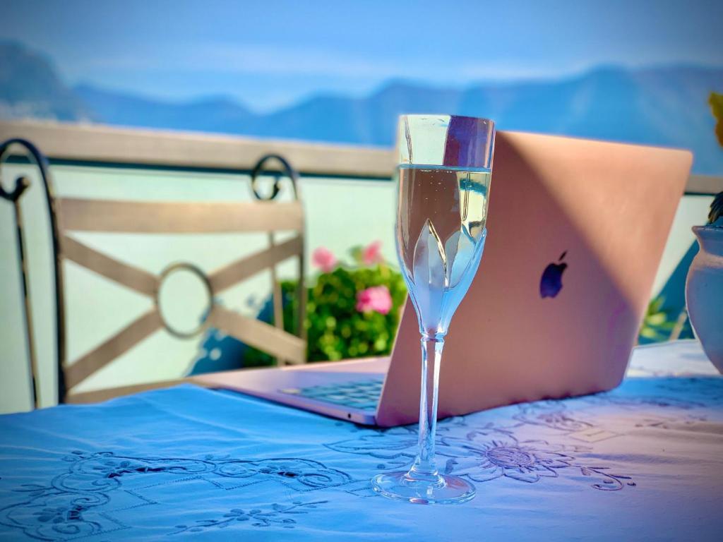 a glass of wine sitting on a table with a laptop at Zorab&b in Breganzona