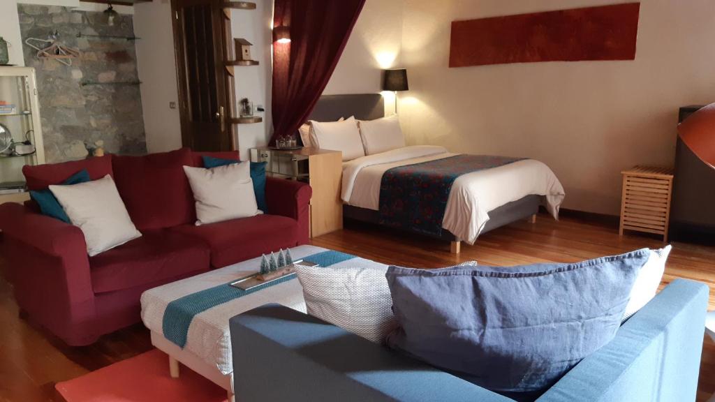 um quarto de hotel com um sofá e uma cama em À Deux Pas ... em Briançon