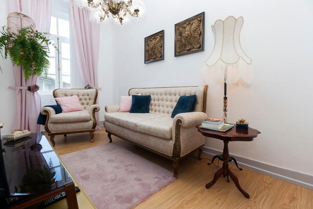 a living room with two chairs and a couch and a table at Casa Dourada in Barcelos