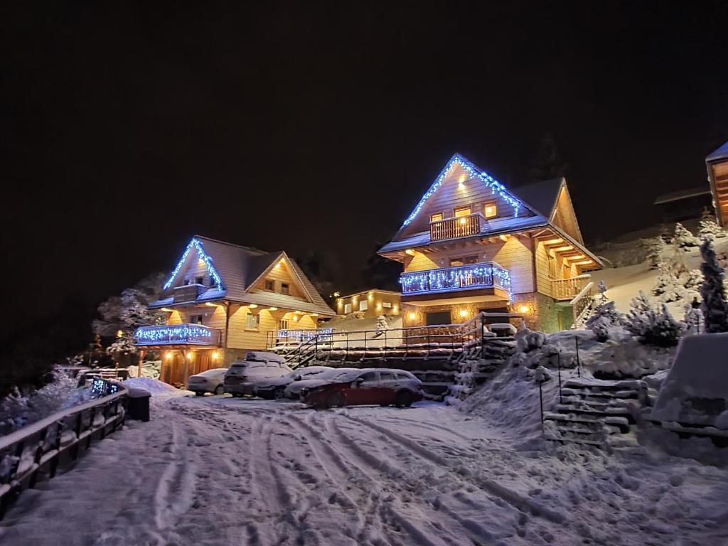 a house with blue lights on it in the snow at Osada Jaworki B&B in Jaworki