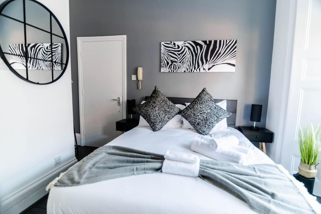 a bedroom with a white bed with zebra prints on the wall at Chic Studio Apartment in Prime London Location in London
