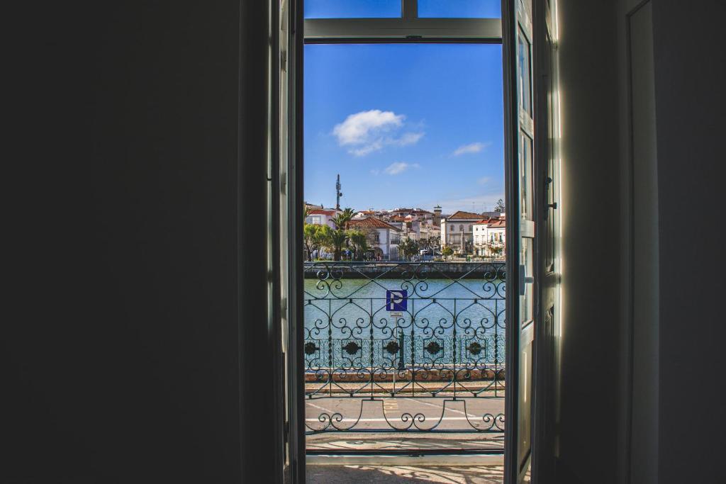 uma porta aberta com vista para uma varanda em Apartamentos do Rio em Tavira