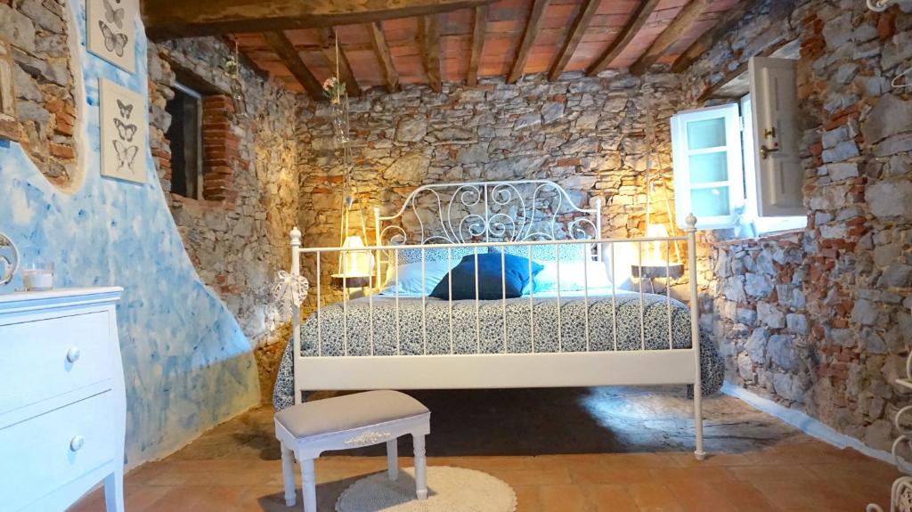 sypialnia z łóżkiem w kamiennej ścianie w obiekcie Agriturismo le Vallilunghe w Lukce