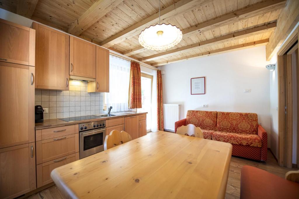 a kitchen with a wooden table and a couch at Apartments Bea in Ortisei