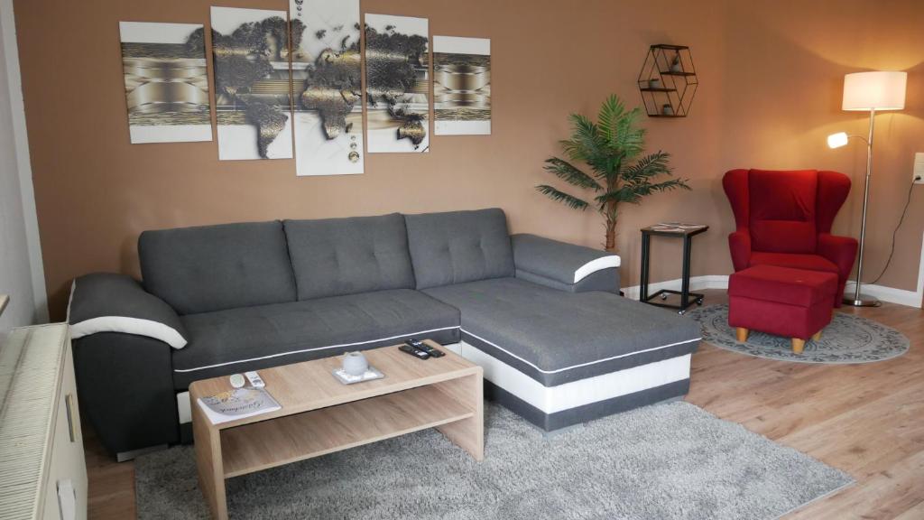 a living room with a couch and a red chair at Wohlfühlen in der Schifferstadt Roßlau in Dessau