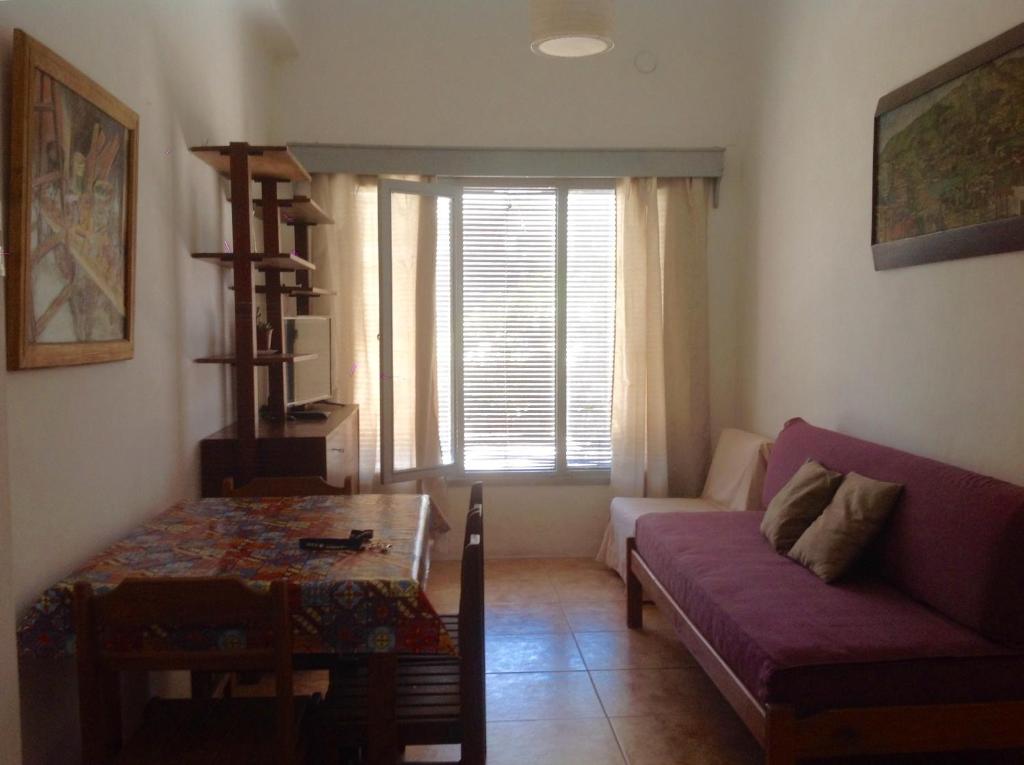 a living room with a purple couch and a table at Artemisa in Piriápolis