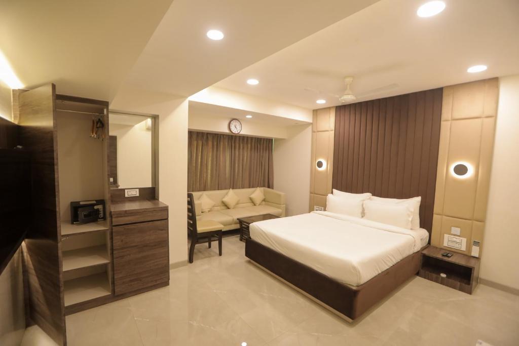 a bedroom with a bed and a chair in it at Hotel Naaz Executive in Mumbai