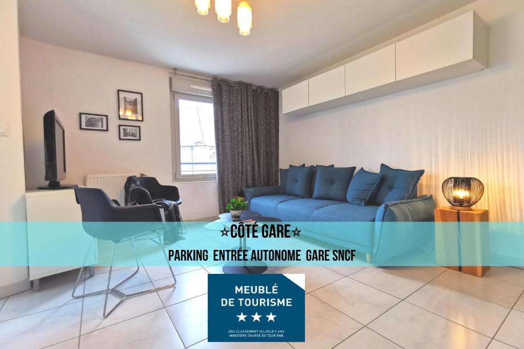 a living room with a blue couch and a glass table at CÔTÉ GARE - Gare - Centre-ville - Parking - Netflix - Wifi - Disney+ - Terrasse in Annecy