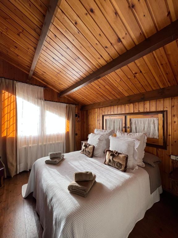 um quarto com uma cama grande e toalhas em Xalet de Cal Fera em La Coma i la Pedra