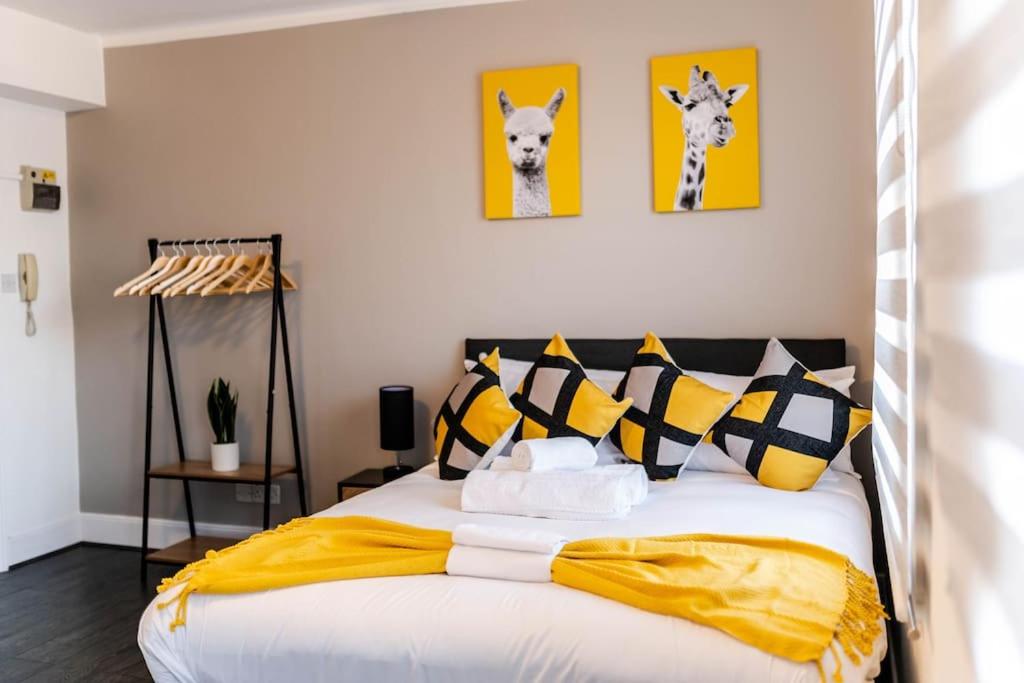 a bedroom with a bed with yellow and black pillows at Charming Studio Retreat I1Bed1Bath Haven in London in London