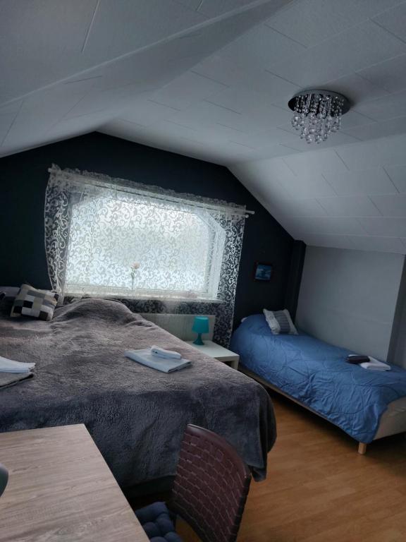 a bedroom with two beds and a window at Twin room with shared bathroom in Ytri-Njarðvík