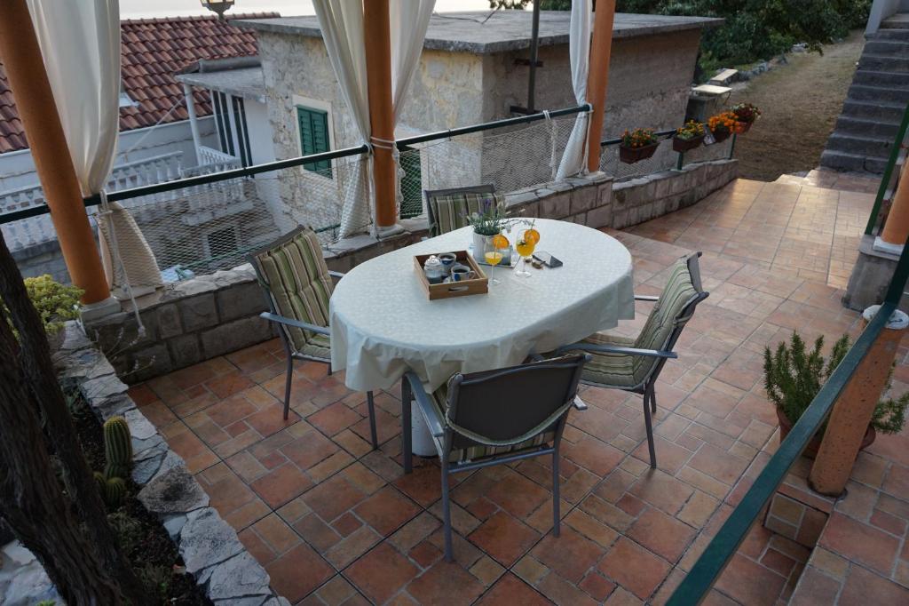 Biały stół i krzesła na patio w obiekcie Holiday House Terezija w Baskiej Vodzie
