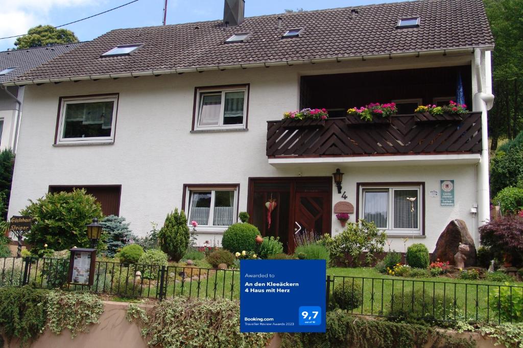 una casa con un cartel delante de ella en An den Kleeäckern 4 Haus mit Herz en Ramberg