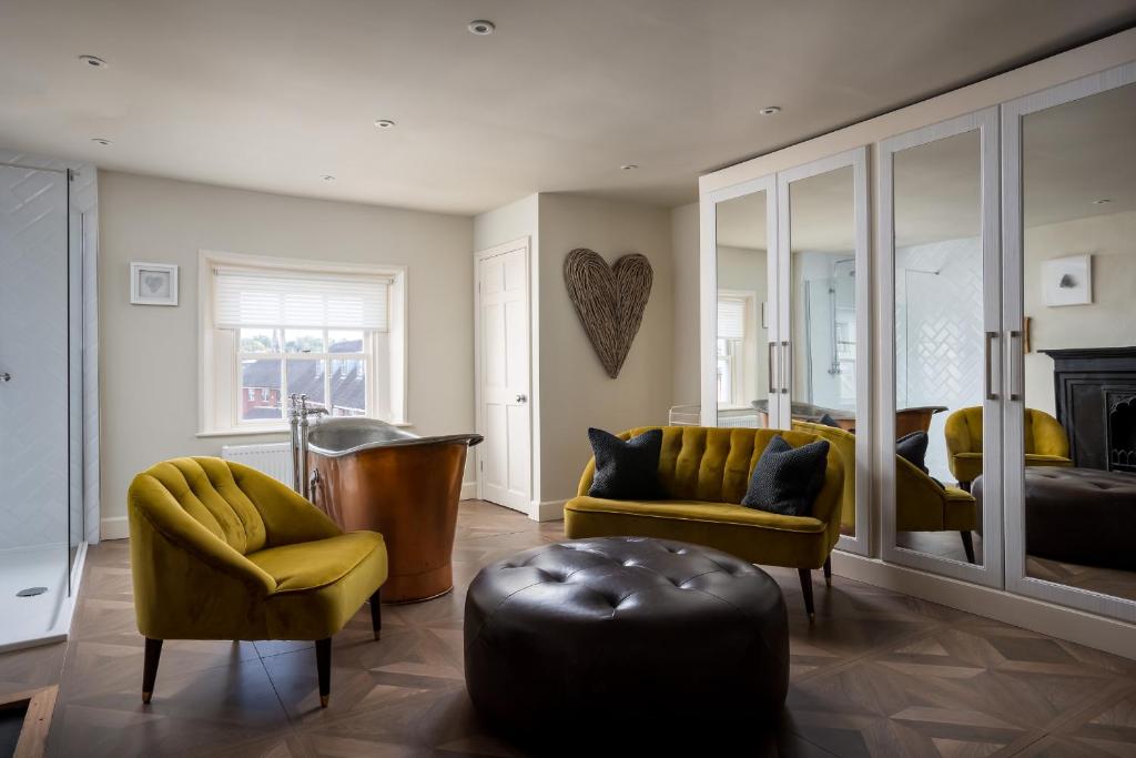 a living room with yellow furniture and a bedroom at St Johns House Lichfield in Lichfield